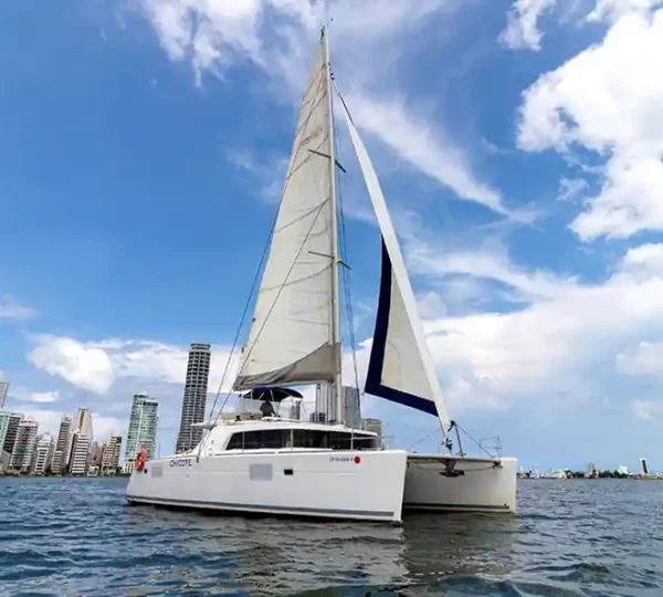 Catamarán Chicote navegando a vela frente al skyline de Cartagena
