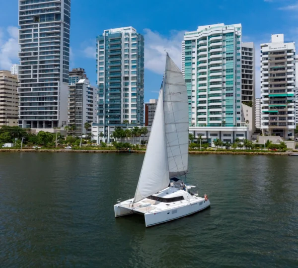 Catamarán Chicote navegando a vela frente al skyline de Cartagena