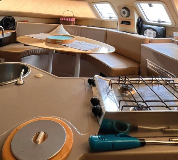 Cocina a bordo del Catamarán Armonia con estufa y comedor