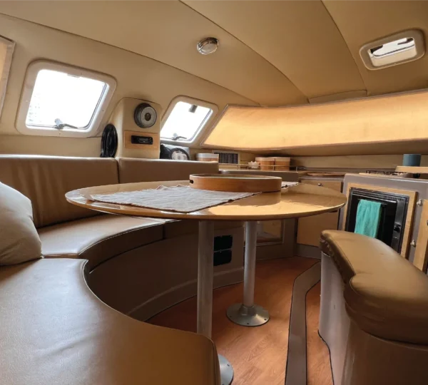 Sala interior y comedor circular del Catamarán Armonia con vista a las ventanas